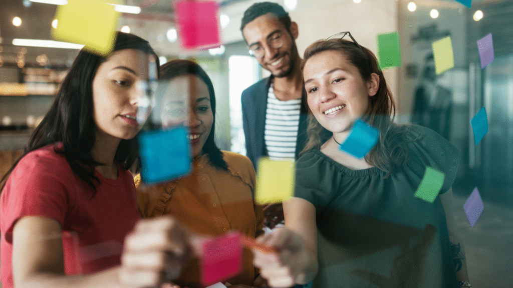 Grupo de jóvenes profesionales colaborando en una sesión de ideas con notas adhesivas de colores.
