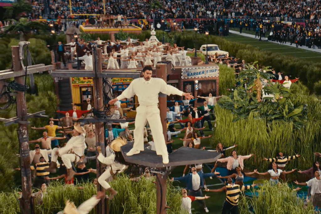 Vista aérea del escenario completo del medio tiempo del Super Bowl 2026, mostrando una escenografía comunitaria y participación colectiva.